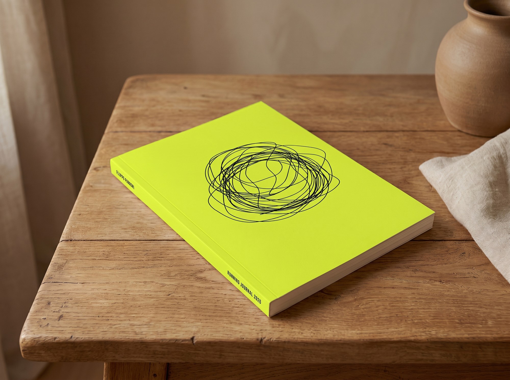 The orma annual running journal, a yellow softcover book resting on an oak table